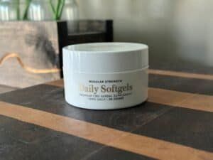 CBD softgels container on a wooden surface for health and wellness.